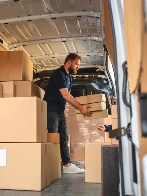 Operario de Mudanzas Bumerán colocando cajas dentro de la furgoneta durante una mudanza