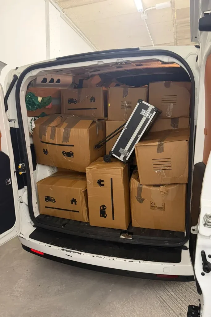 Furgoneta cargada de cajas y un carro de transporte durante una mudanza pequeña
