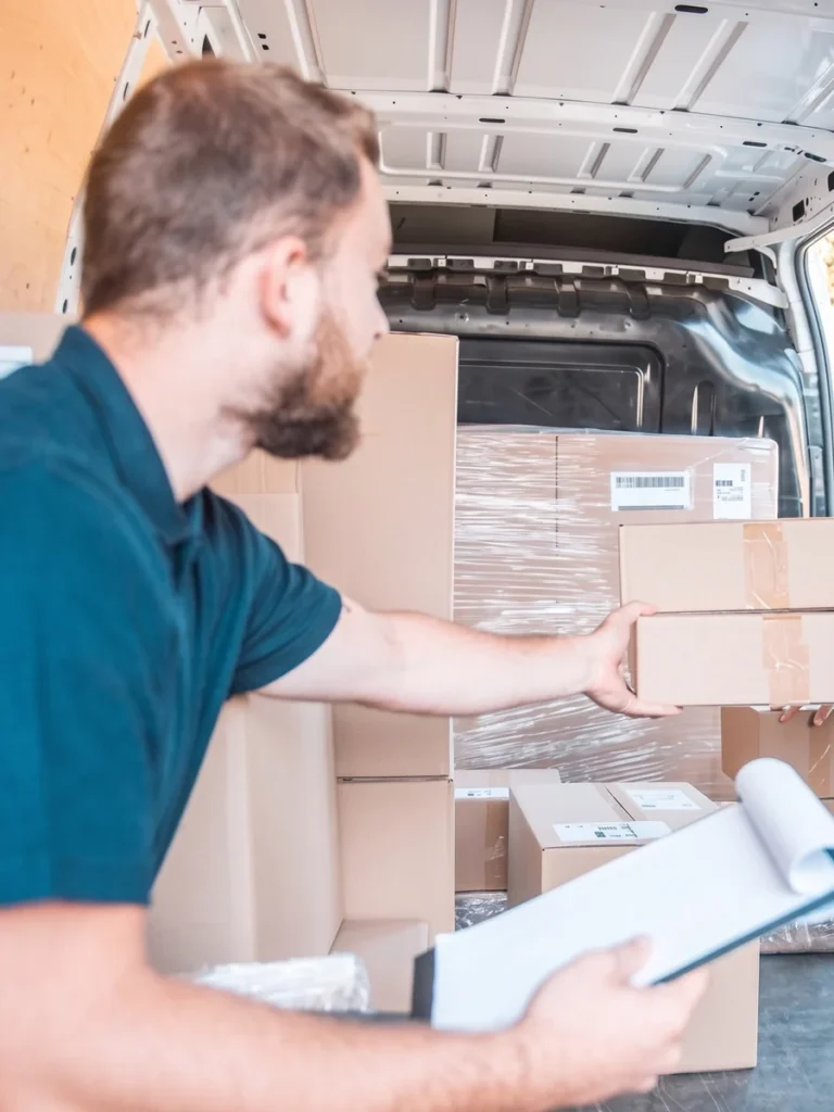 Operario de Mudanzas Bumerán revisando el inventario de cajas con un portapapeles antes de cargar la furgoneta